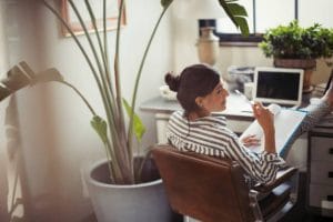 Jeune femme qui travaille dans son garage aménagé en bureau personnel